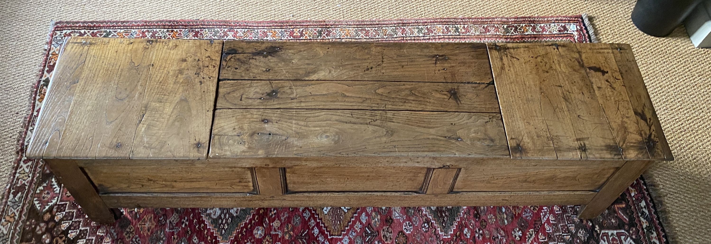 A 17th century style elm blanket box, with central rising lid and panelled front, width 180cm depth 44cm height 51cm